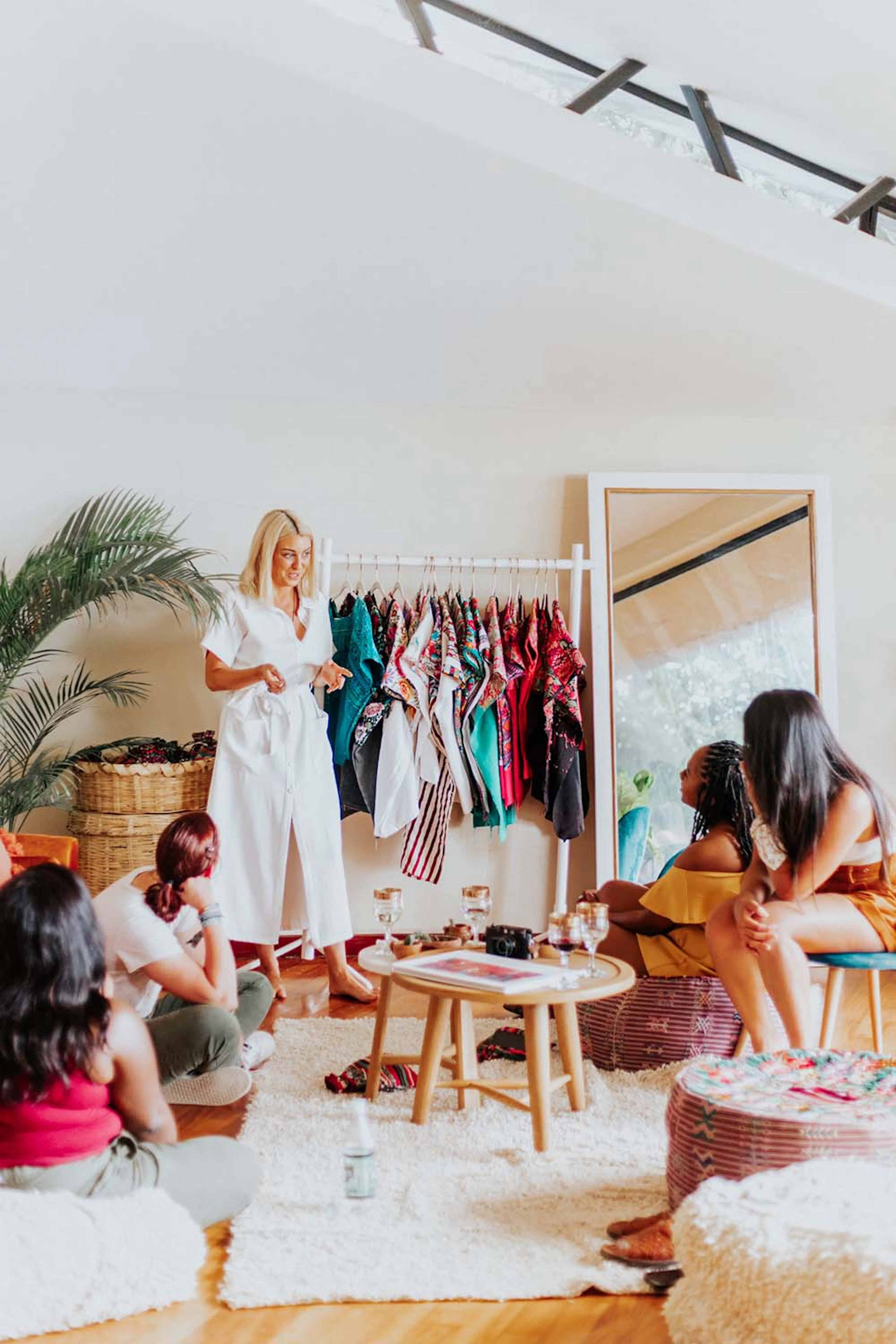 Women browsing a clothing rack and chatting in a bright studio