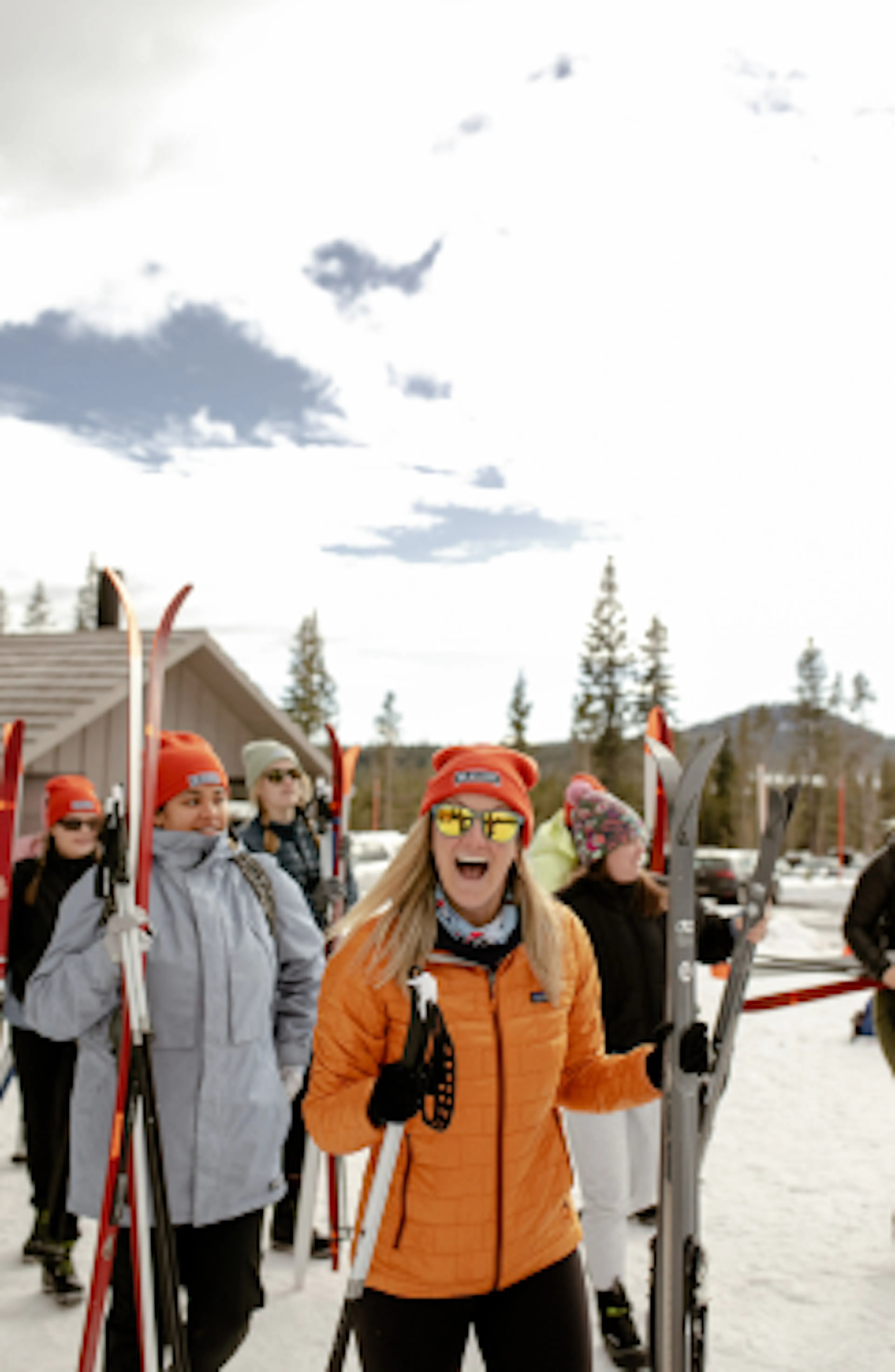 Women in ski gear smiling at a snowy trailhead