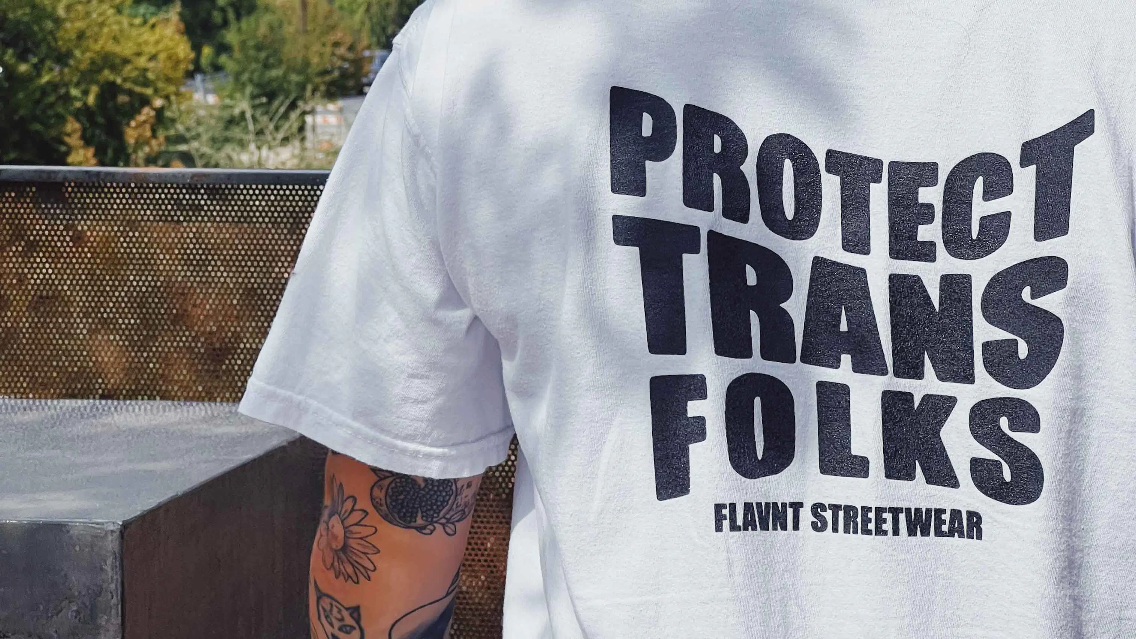 A white FLAVNT Streetwear T-shirt reading “Protect Trans Folks”