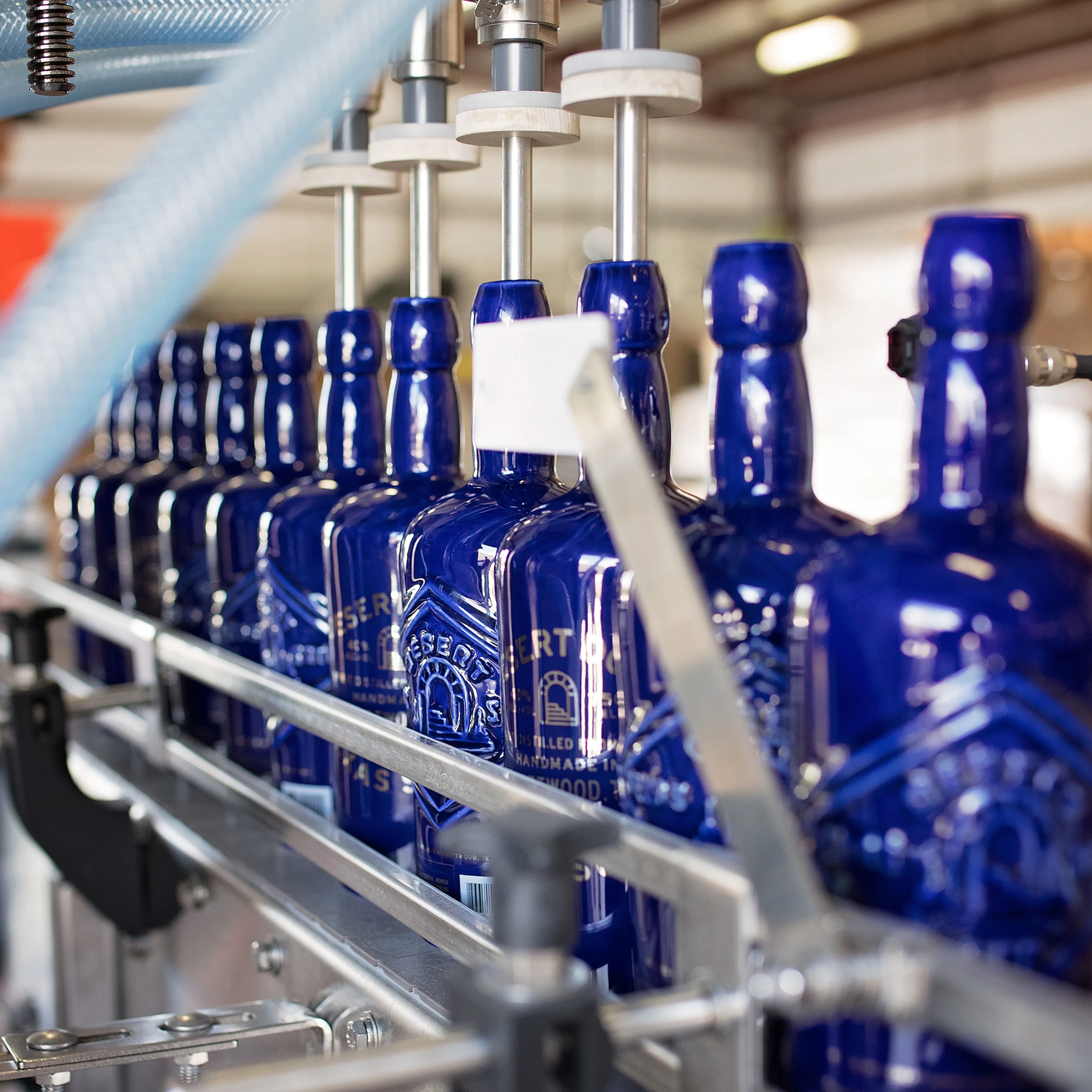 Blue Desert Door bottles moving along a bottling line
