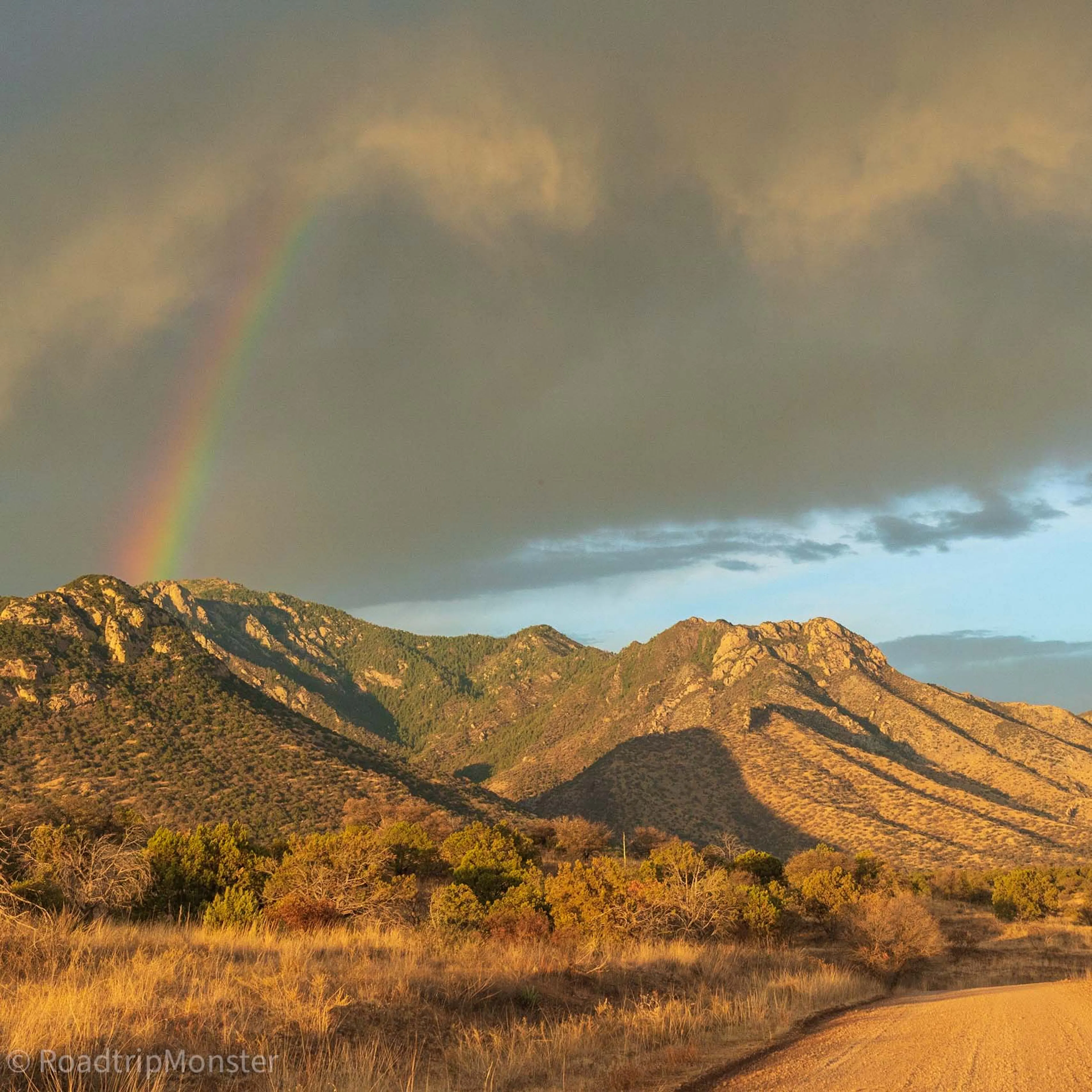 A rainbow over desert mountains at sunset