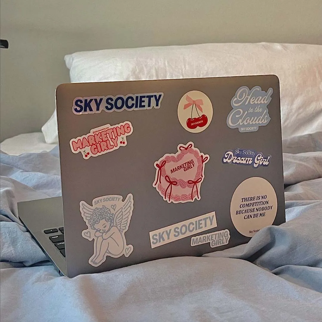 A laptop covered in Sky Society and Marketing Girly stickers