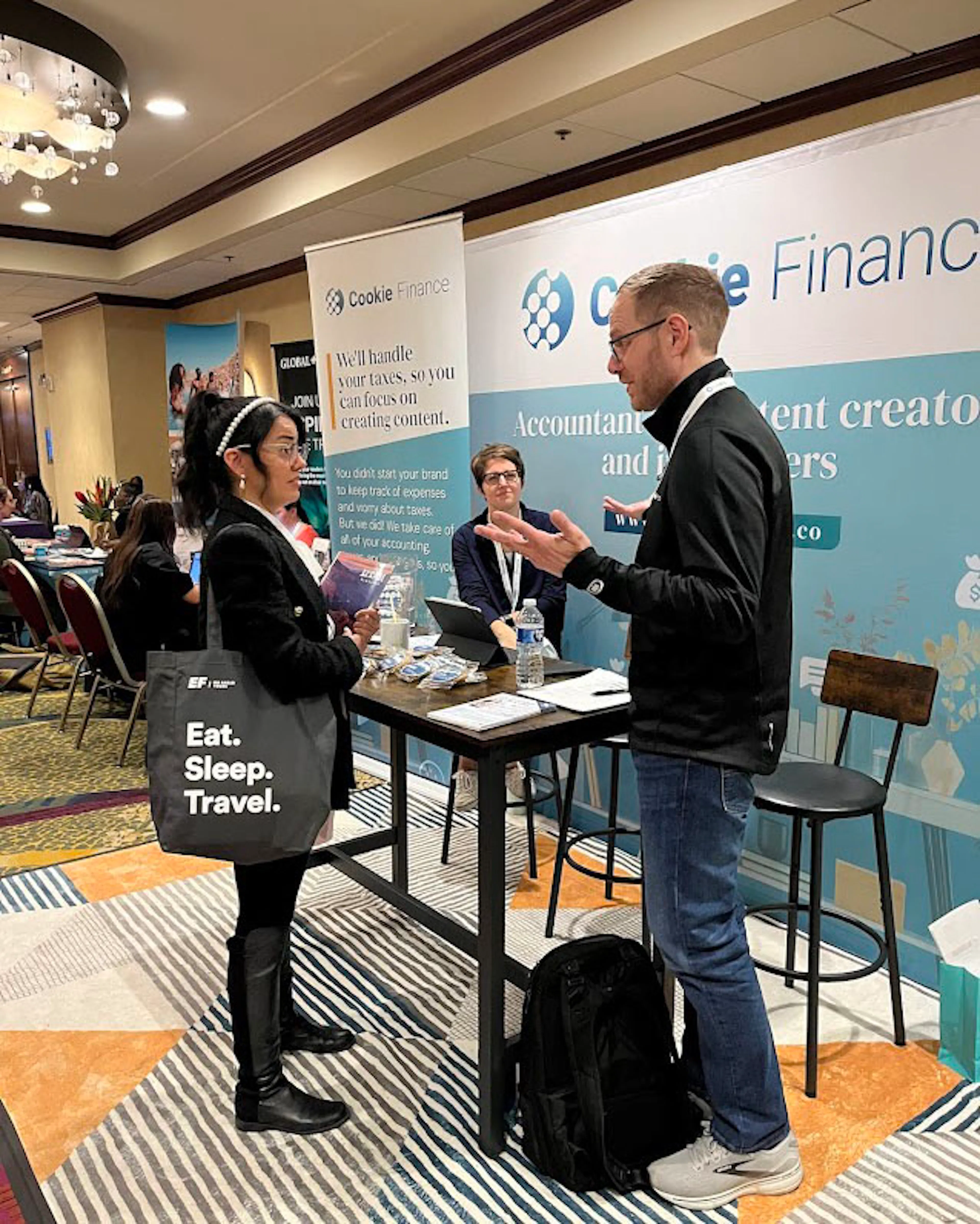 Nate Coughran talking with a visitor at the Cookie Finance booth