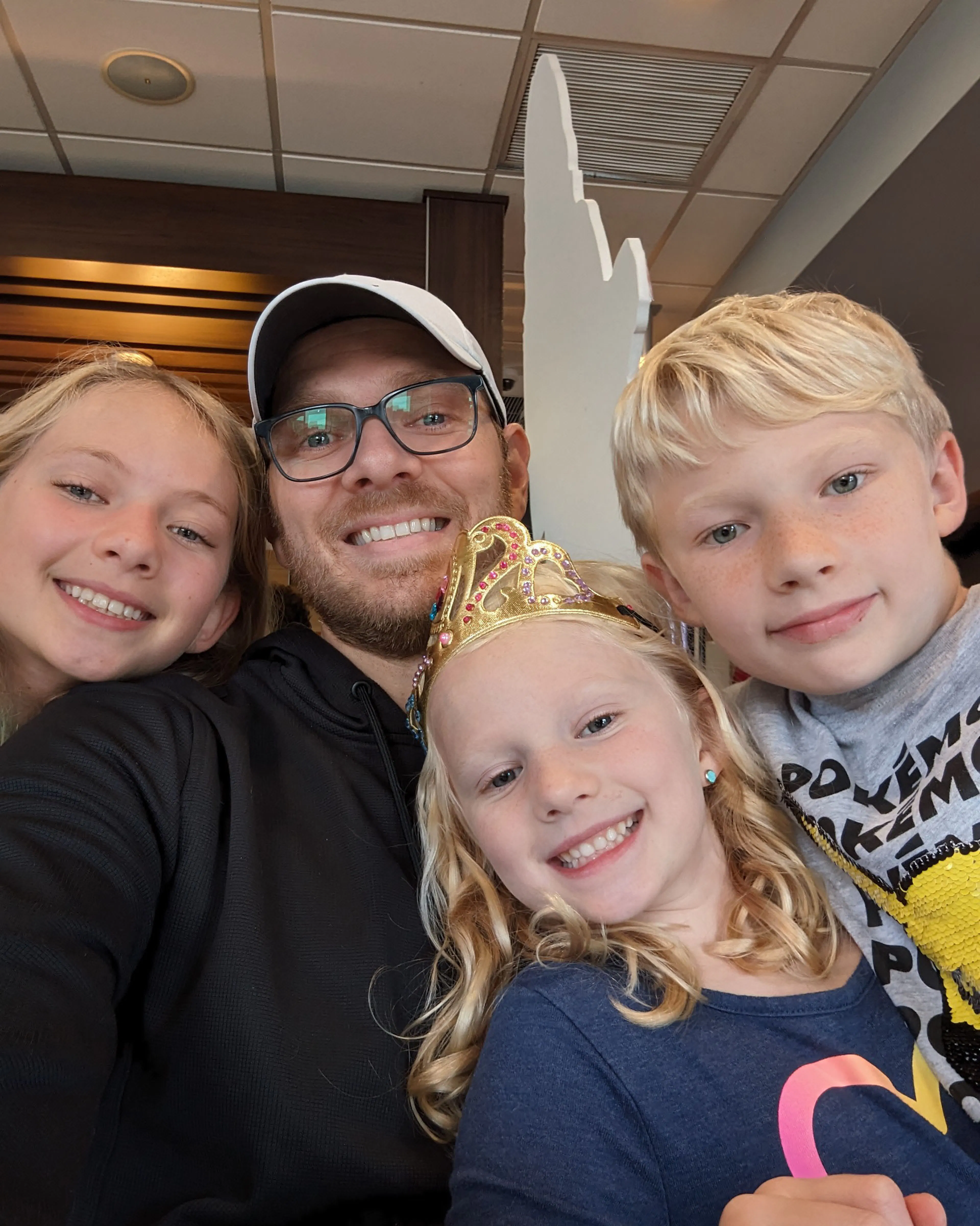 Nate Coughran taking a selfie with three children