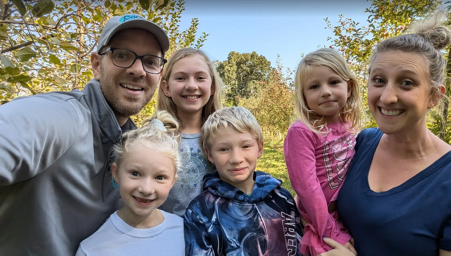 Nate Coughran taking an outdoor selfie with a woman and four children