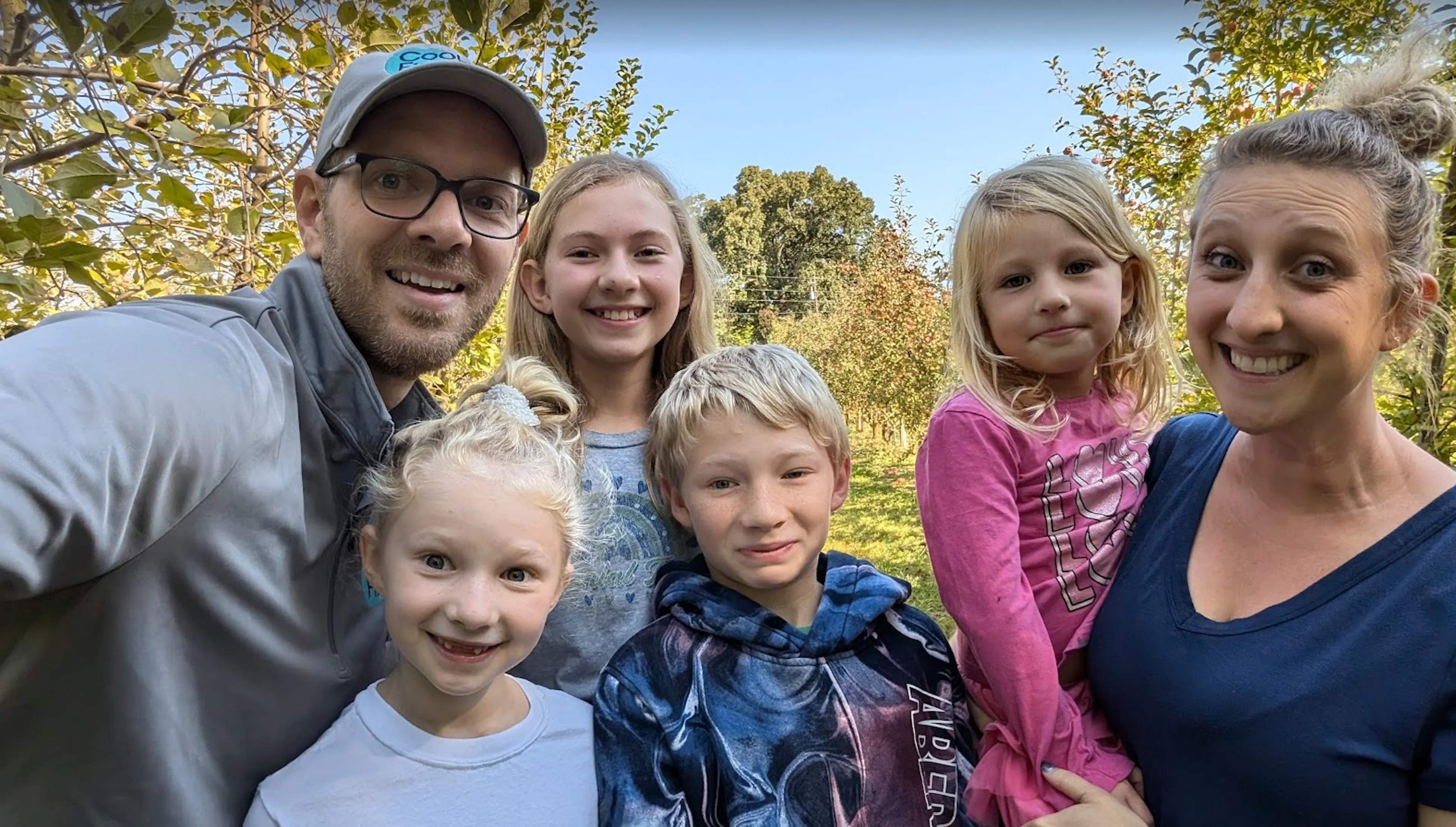 Nate Coughran taking an outdoor selfie with a woman and four children