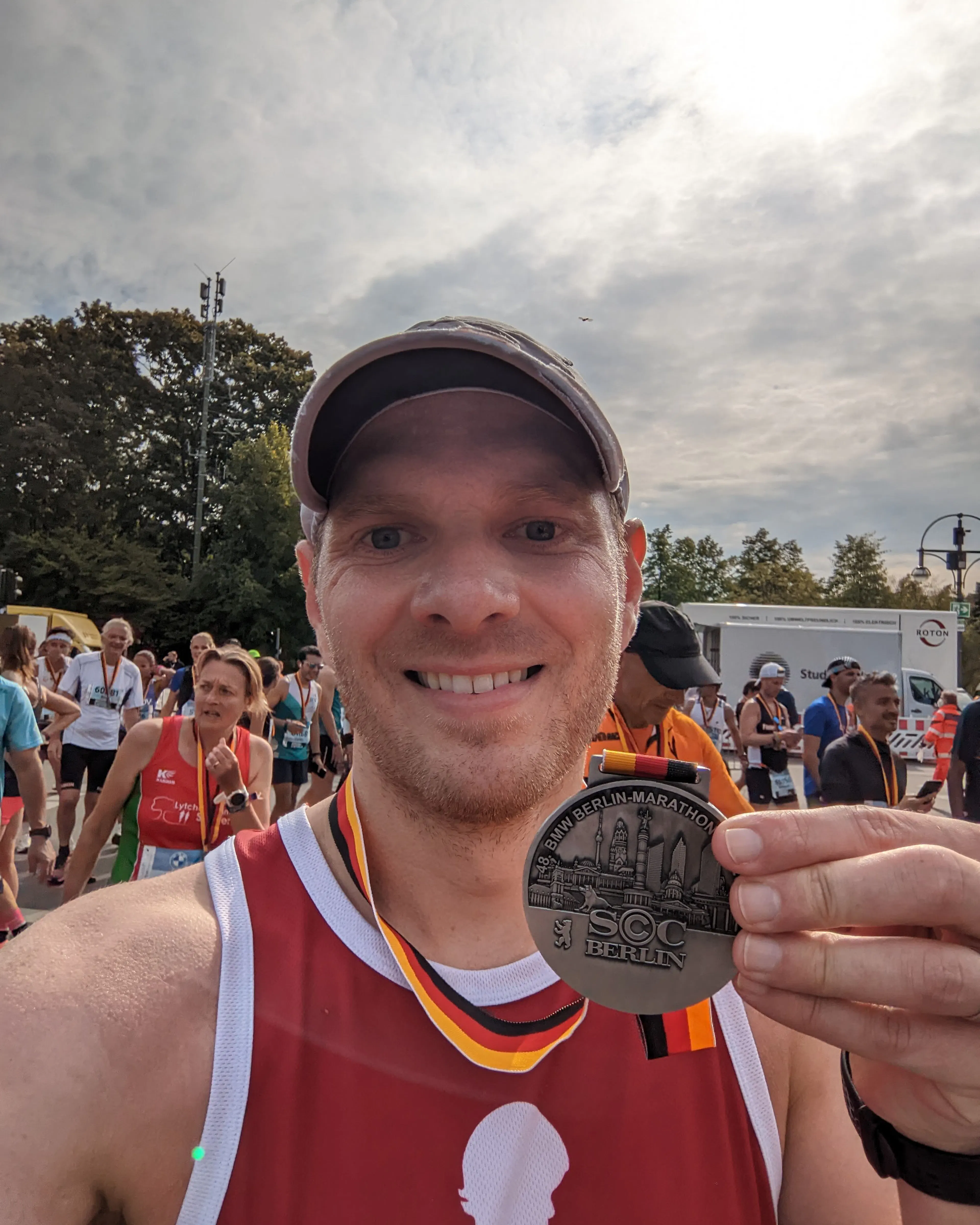 Nate Coughran holding up a medal after a marathon