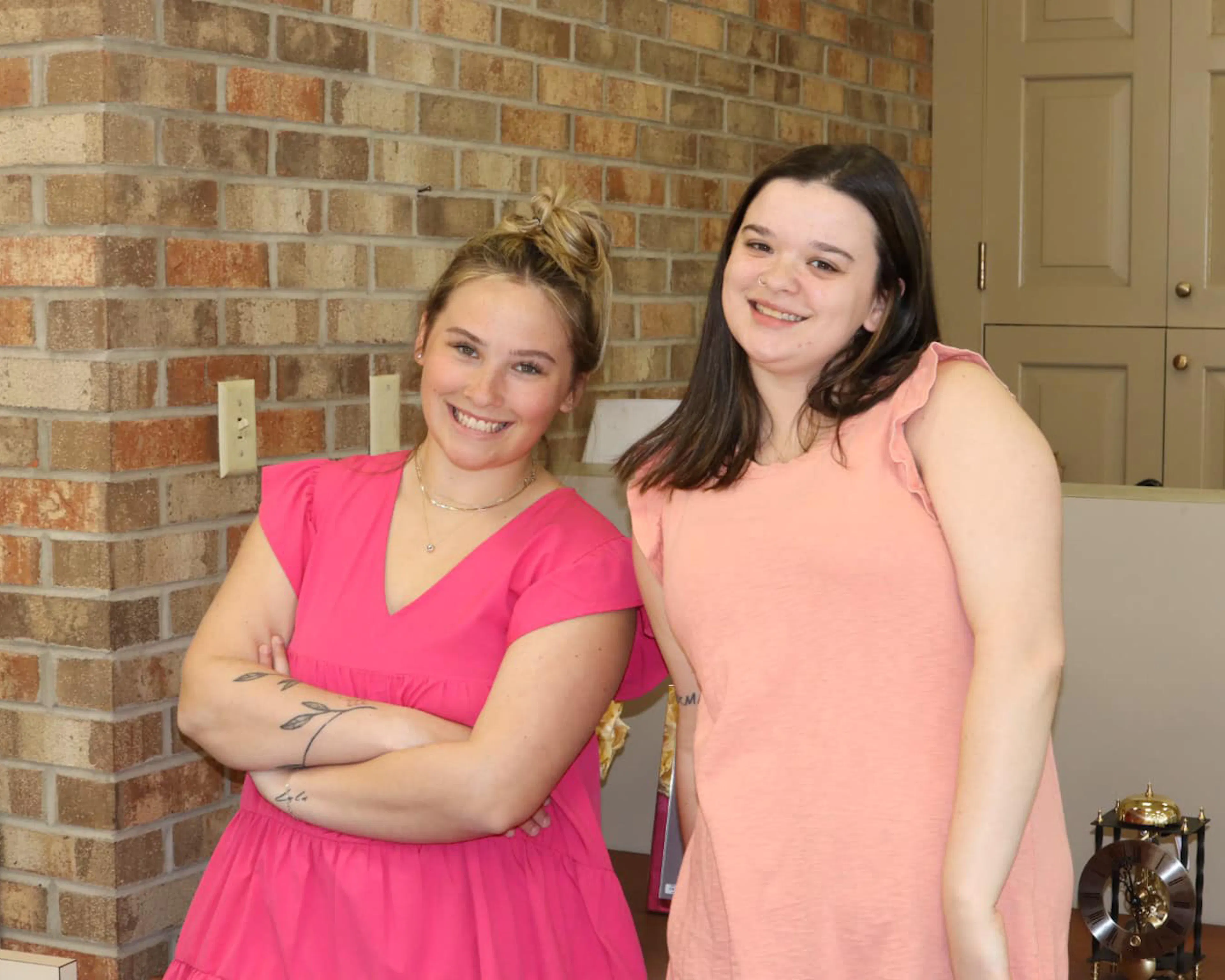 Two smiling team members in pink dresses in the store