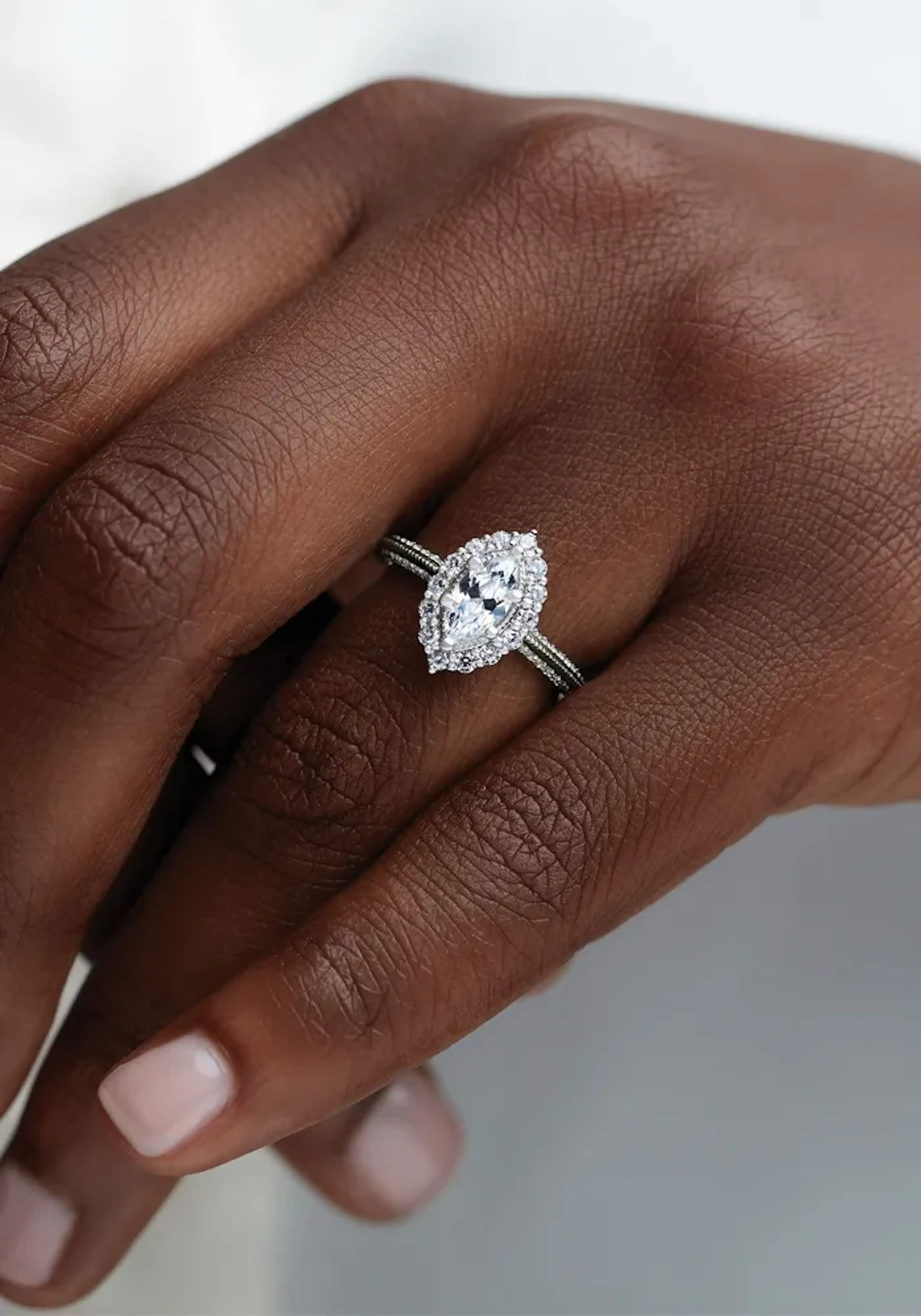 A marquise diamond engagement ring worn on a hand