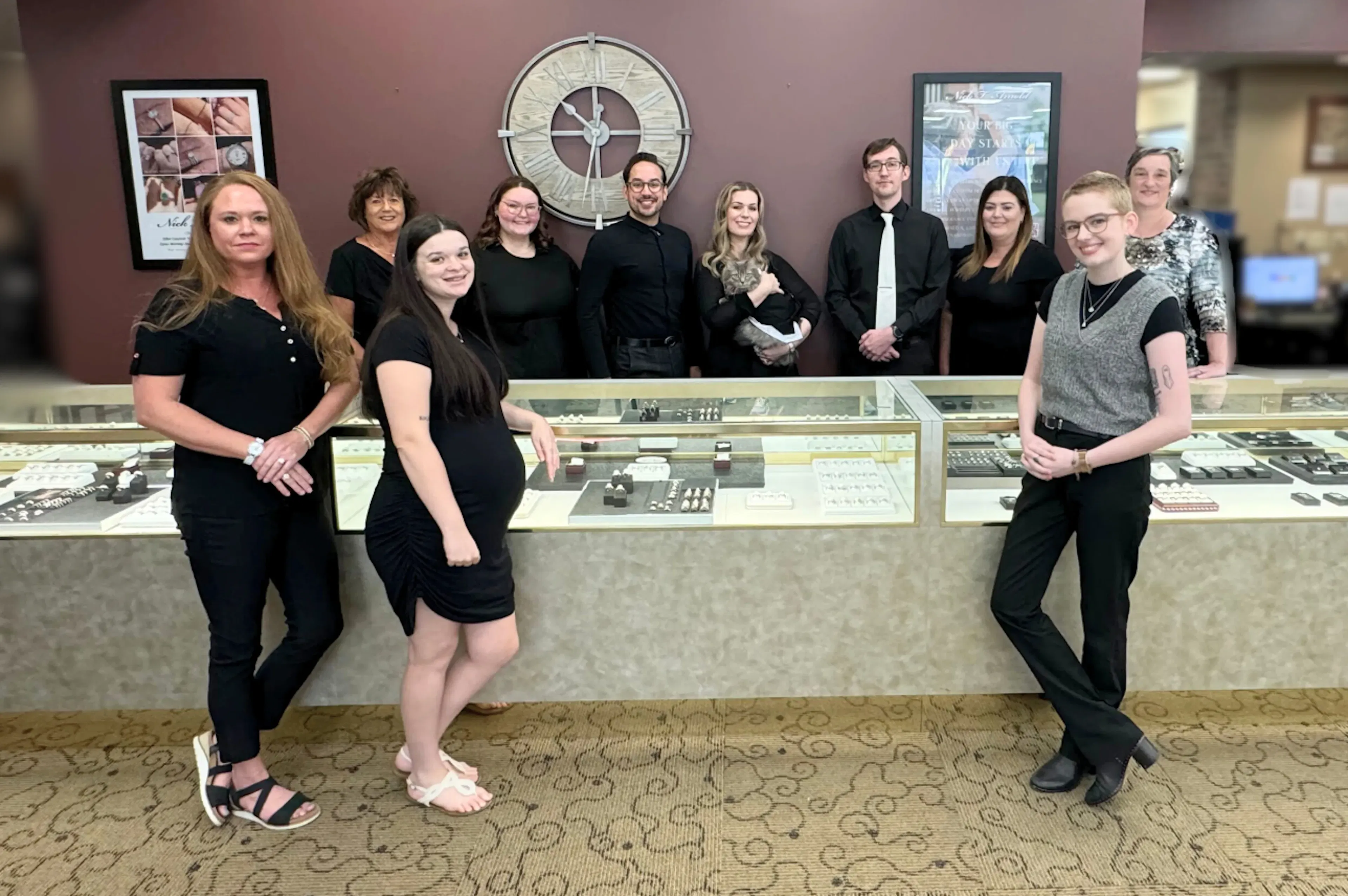 The Nick T. Arnold Jewelers team standing in front of the store’s display cases